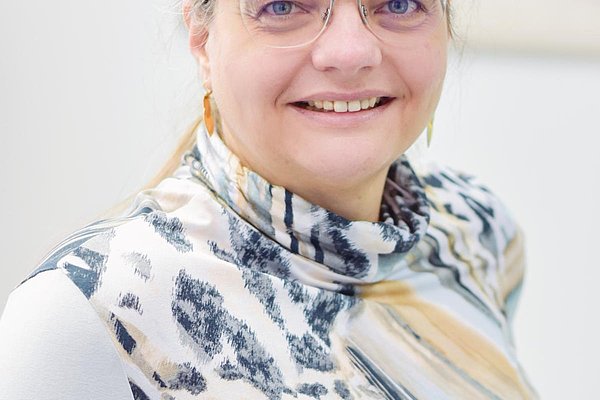Dr. Melanie Metzenthin l&auml;chelt im Portr&auml;t in die Kamera. 