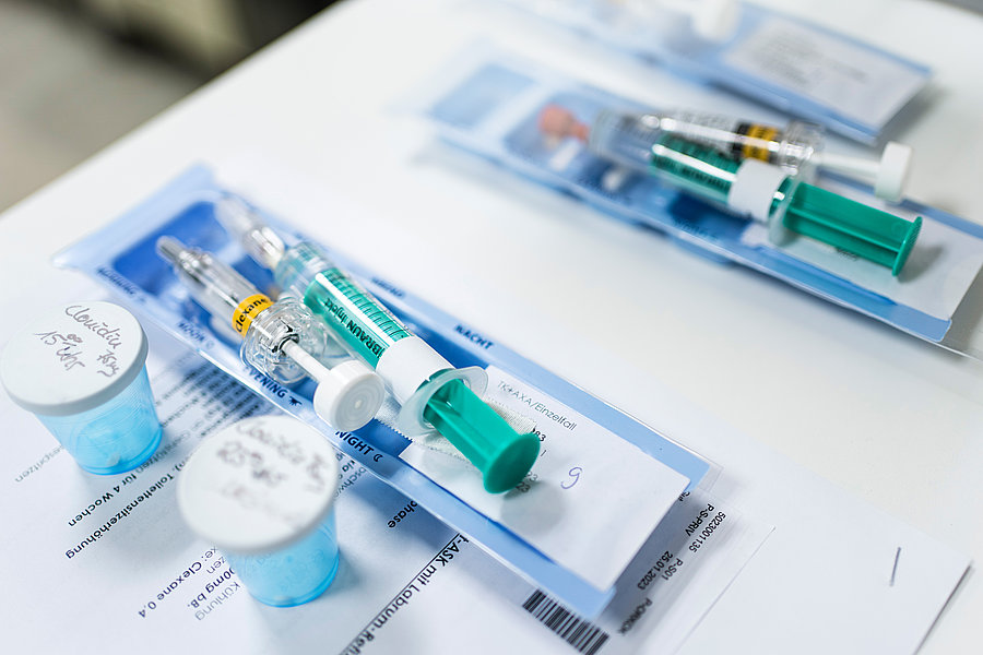 Spritzen und Tabletten liegen auf einem Tisch